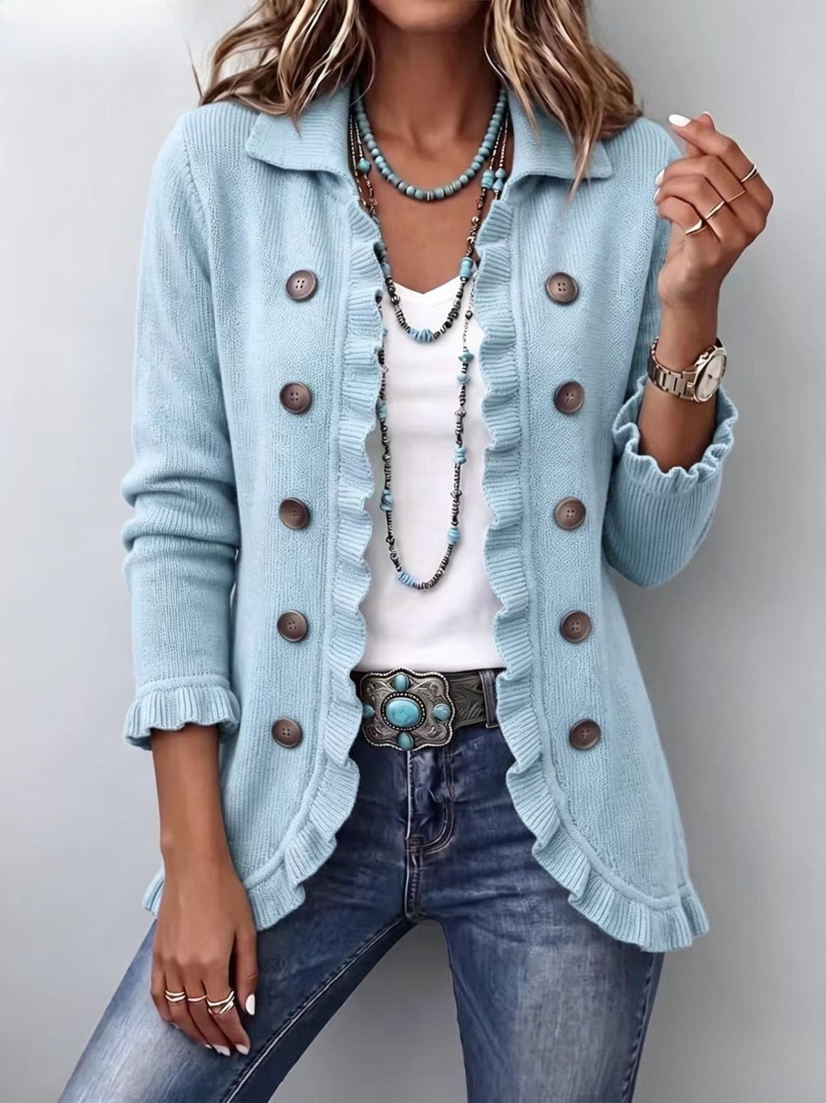 Chaqueta de punto azul empolvado con volantes, botones grandes y puños acanalados.