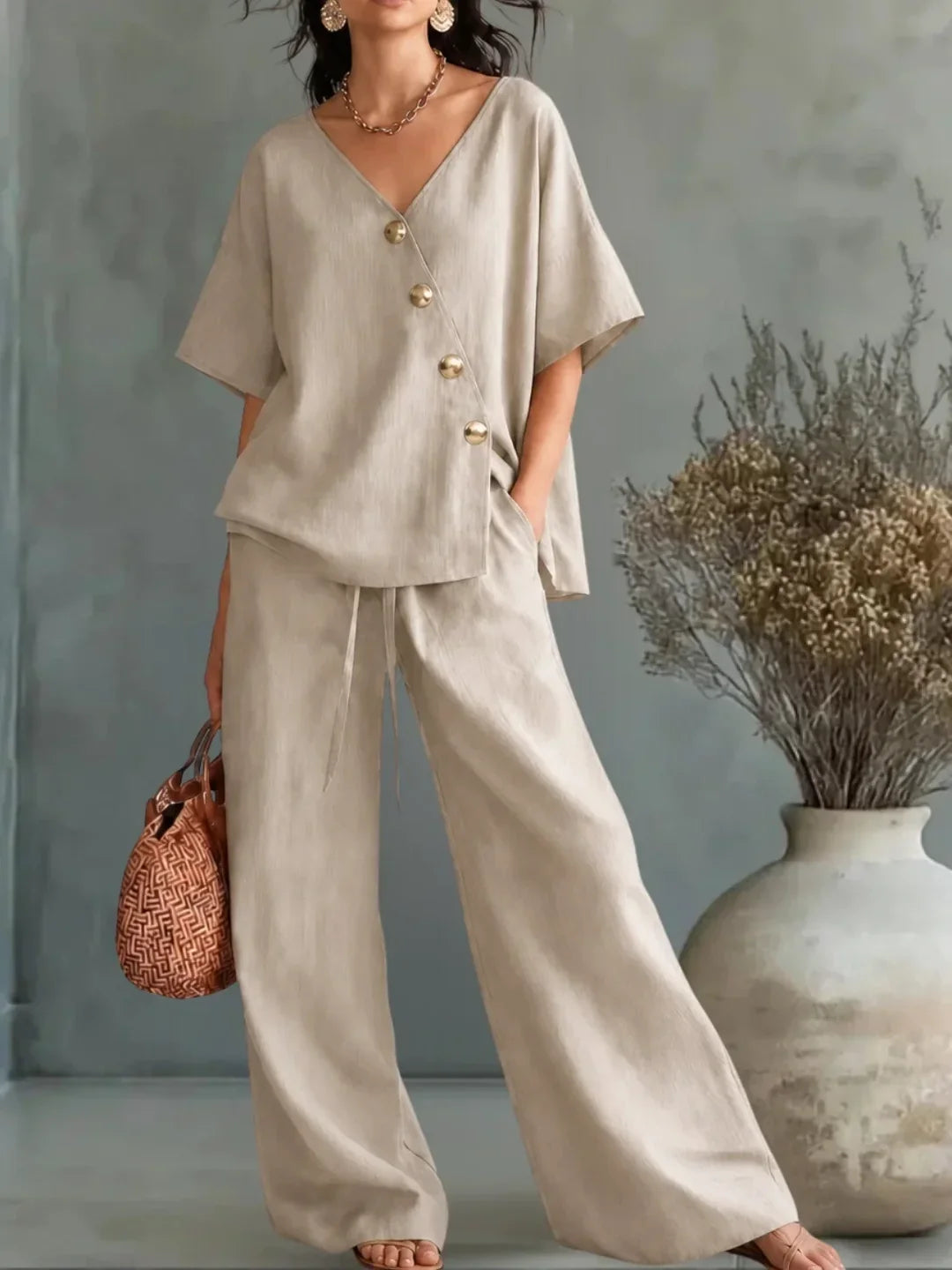Conjunto beige: blusa con escote V y botones dorados, y pantalón ancho.