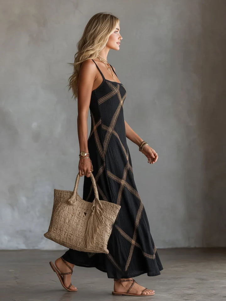 Vestido maxi negro con tirantes finos y patrón geométrico dorado, largo hasta el tobillo