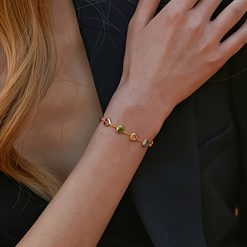 Pulsera de corazones multicolor con cadena dorada en la mano