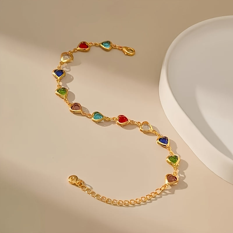 Pulsera de corazones multicolor con cadena dorada extendida sobre fondo claro