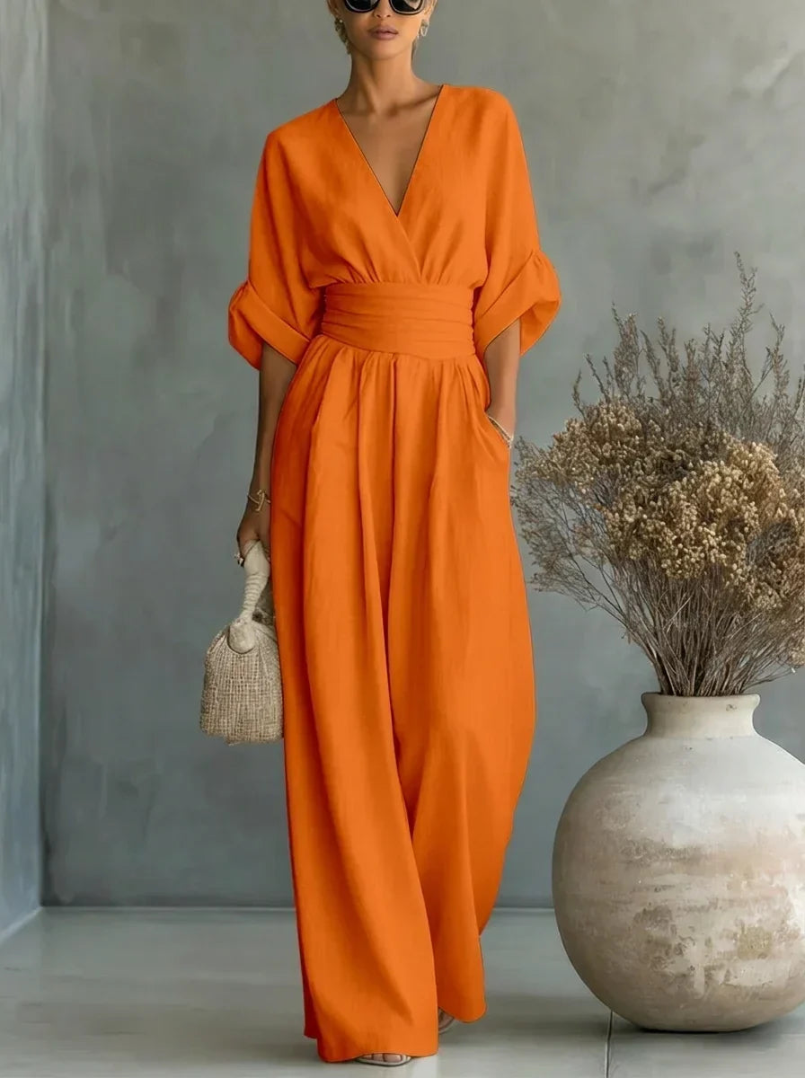 Vestido largo naranja con escote en V y cintura fruncida, mangas caídas y falda amplia.
