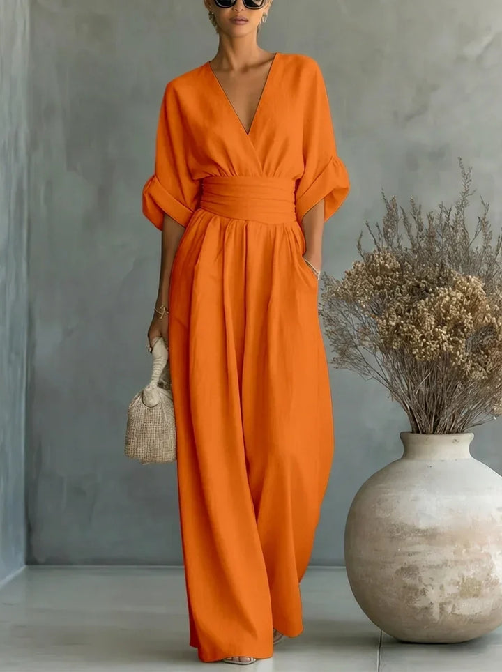 Vestido largo naranja con escote en V y cintura fruncida, mangas caídas y falda amplia.