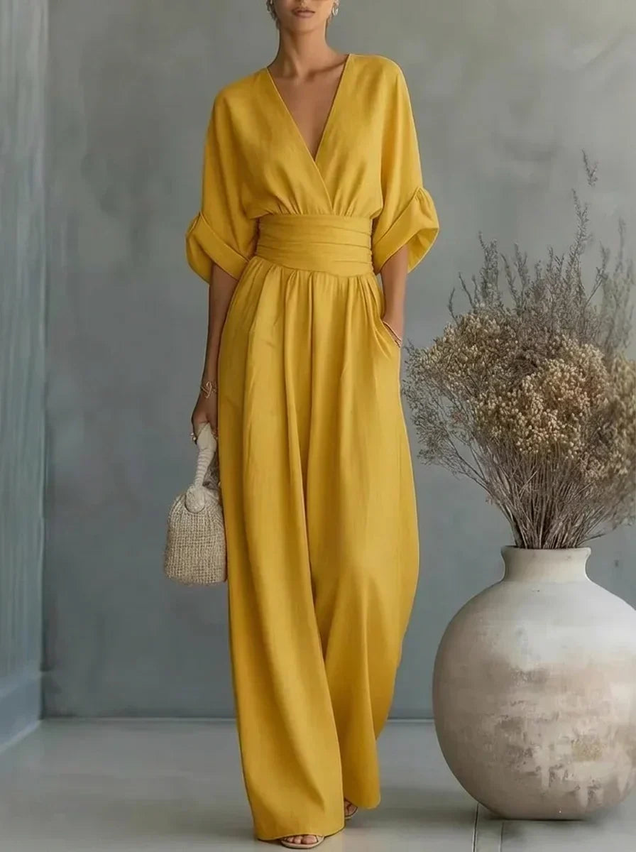 Vestido largo amarillo con escote en V y cintura fruncida, mangas caídas y falda amplia.