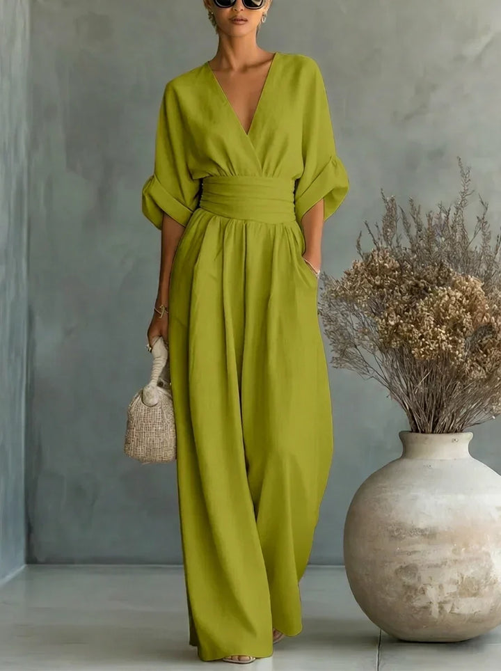 Vestido largo verde con escote en V y cintura fruncida, mangas caídas y caída amplia.