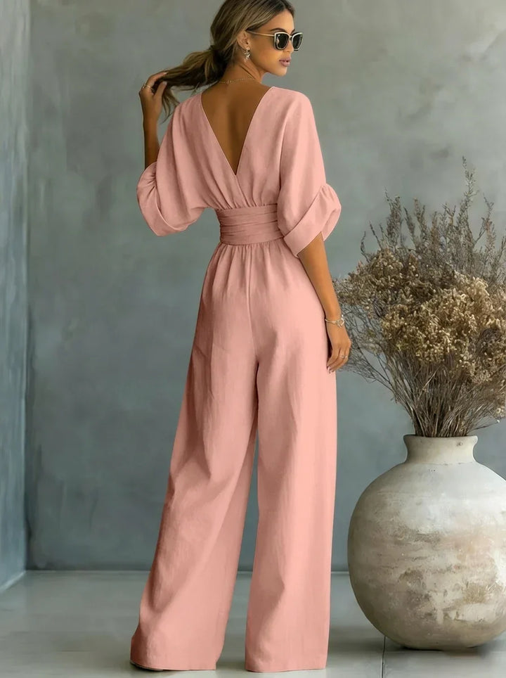 Mono rosa con escote en V, mangas abullonadas y pantalón ancho con cintura fruncida