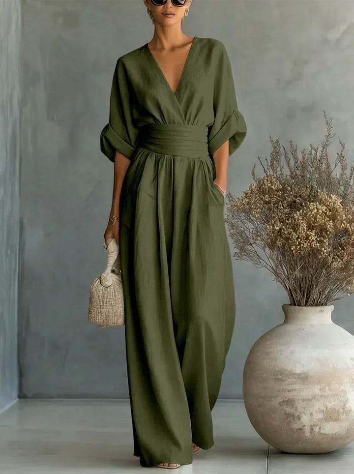 Vestido largo verde oliva con escote en V y cintura fruncida, mangas caídas y falda amplia.