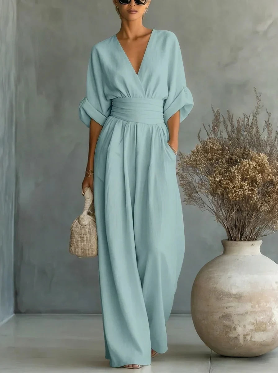 Vestido largo azul claro con escote en V y cintura fruncida, mangas caídas y falda amplia.