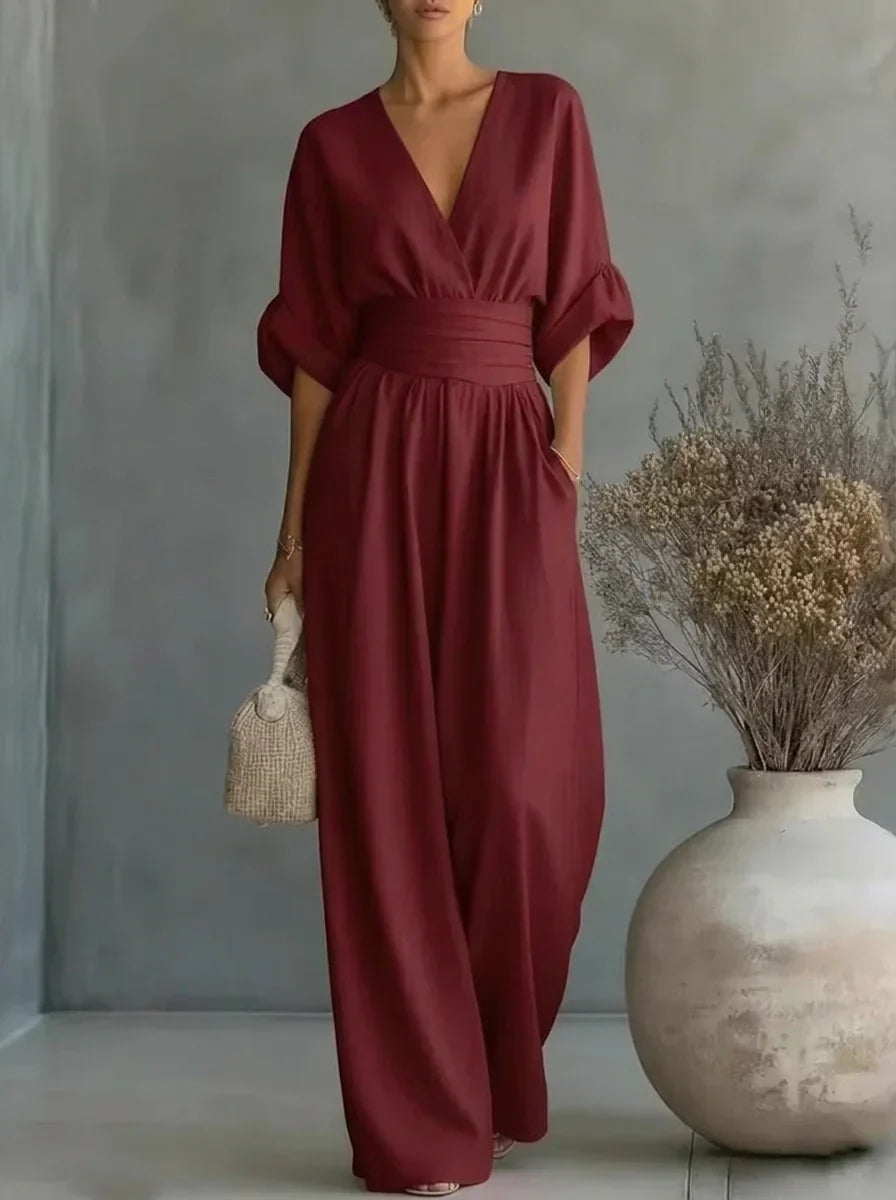 Vestido largo burdeos con escote en V y cintura fruncida, mangas caídas y falda amplia.
