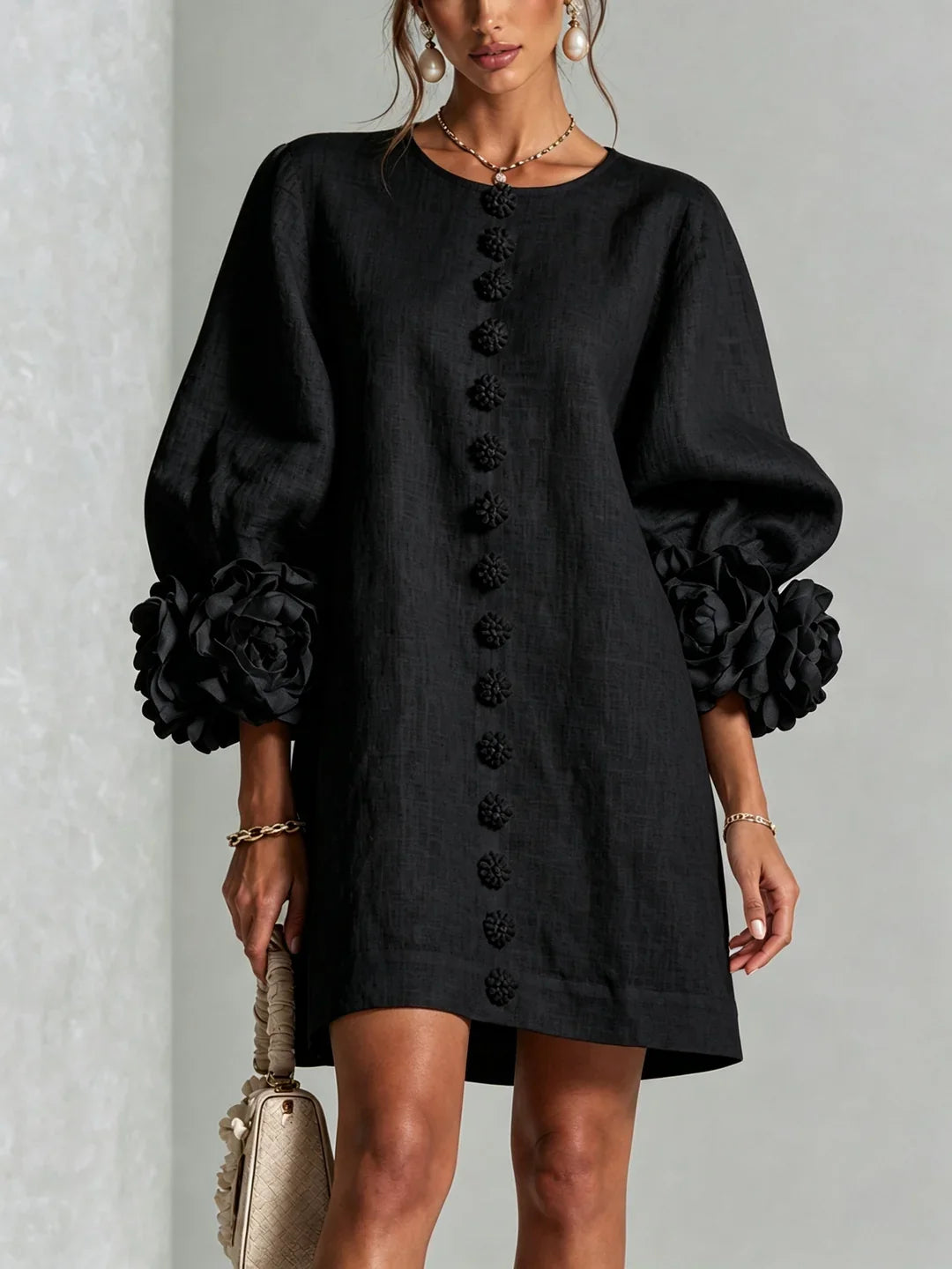 Vestido mini de lino negro, botones florales al centro y mangas abullonadas con flores