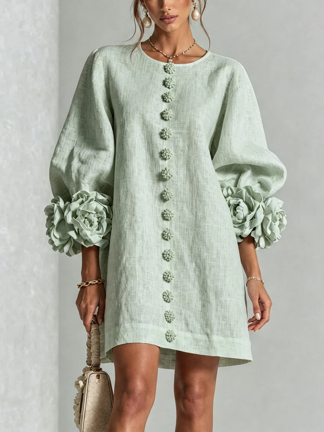 Vestido mini de lino verde claro, botones florales al centro y mangas abullonadas con flores