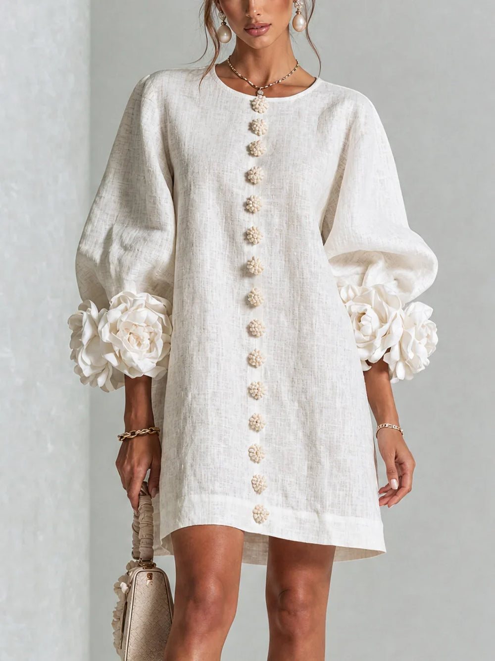 Vestido mini de lino blanco, botones florales al centro y mangas abullonadas con flores