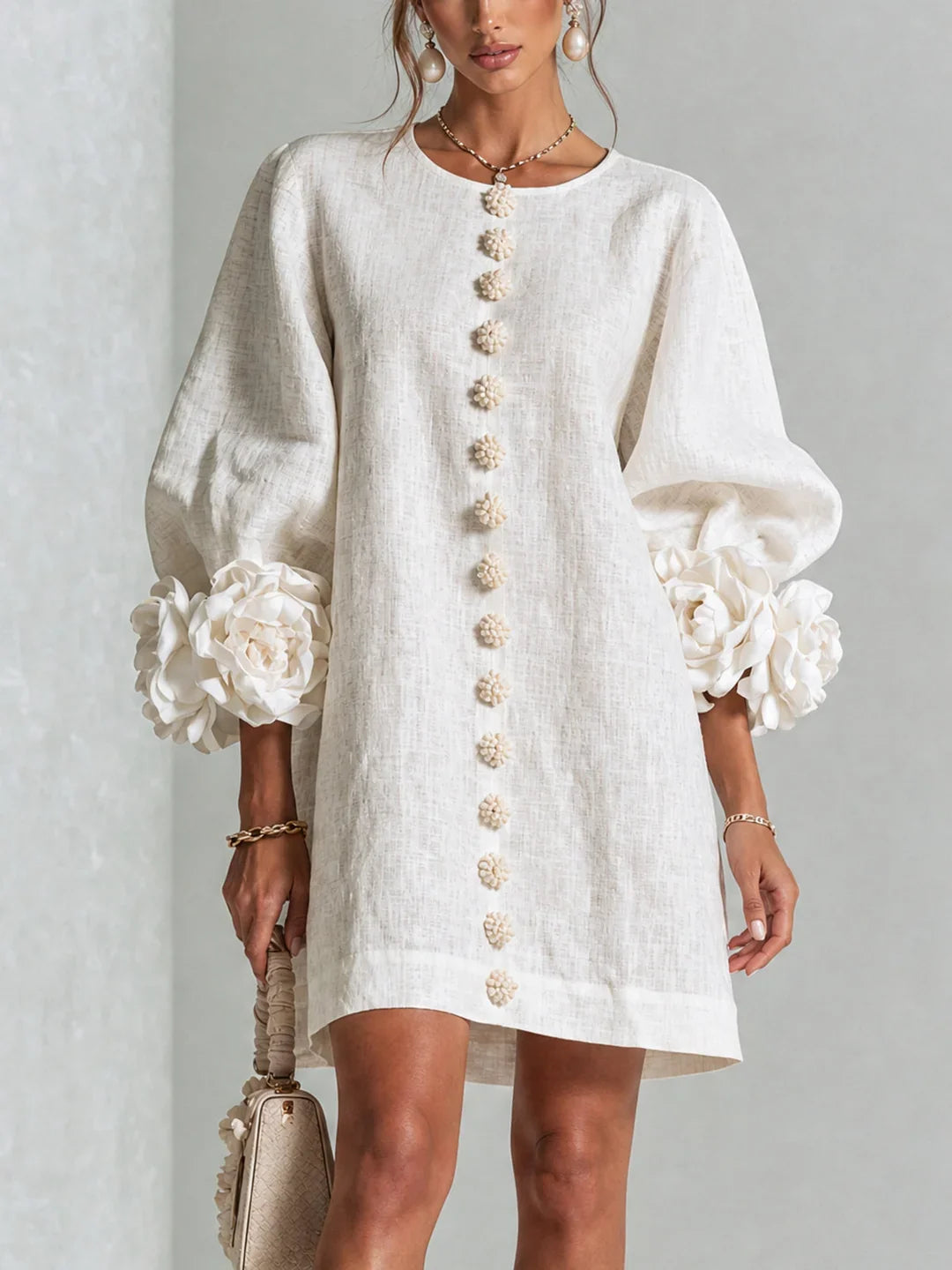 Vestido mini de lino blanco, botones florales al centro y mangas abullonadas con flores