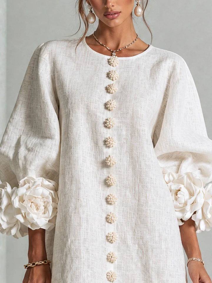 Vestido mini blanco de lino con botones decorativos y mangas abullonadas con flores