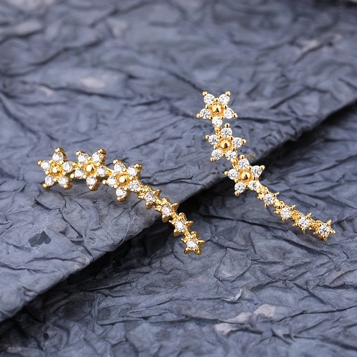 Pendientes florales de pedrería, tono oro, diseño alargado