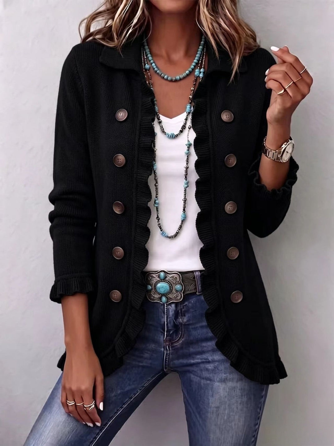 Chaqueta de punto negra con volantes y botones metálicos en la parte delantera