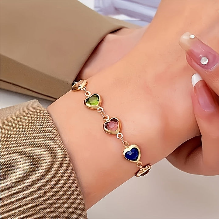 Pulsera de corazones multicolor con cadena dorada usada en la muñeca