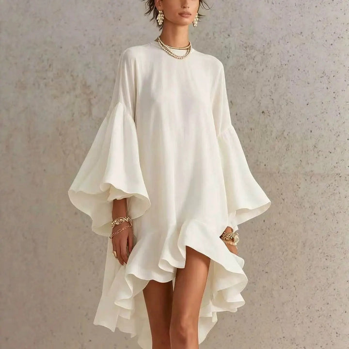 Vestido blanco con volantes y dobladillo asimétrico, mangas campana